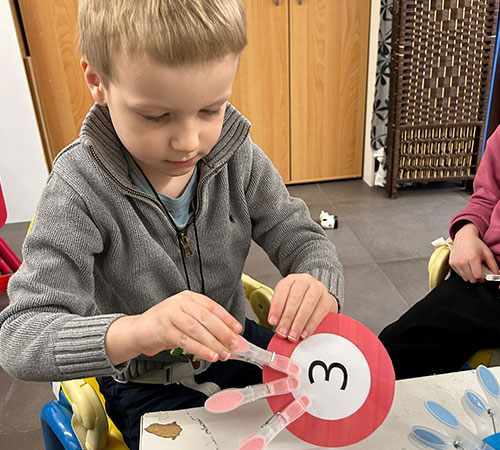 Child taking part in a communication activity with an educator