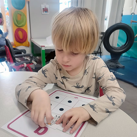 Child working with a teacher on a hands-on activity